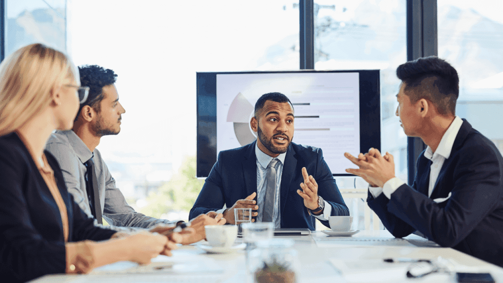 Employer presenting health insurance benefits to a team during a boardroom meeting, illustrating a complete guide to understanding health insurance for individuals and employers