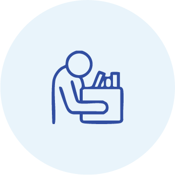 Person reviewing paperwork at a desk icon
